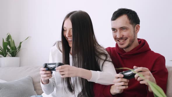 A Pretty Girl and a Boy Are Playing Video Games in the Living Room