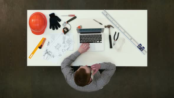 Young Architect Having Important Phone Call About Drawings