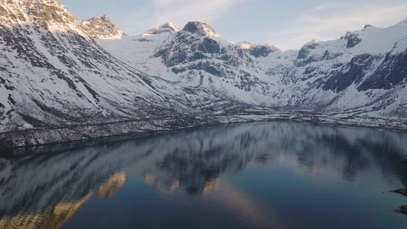 Calm landscape. Snow mountain with blue lake and stunning reflection in water.