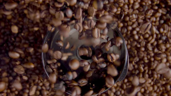 Closeup Coffee Seeds Pouring in Grinder Top View
