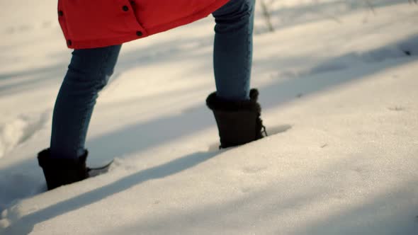 Woman Legs Walking In Snow. Female In Snowy Weather At Cold Temperature Walking Alone.