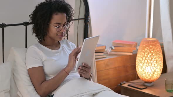 Attractive Young African Woman Using Tablet in Bed 