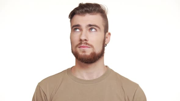 Caucasian Handsome Male in Khaki Tshirt and Brown Beard and Piercing Standing on White Background