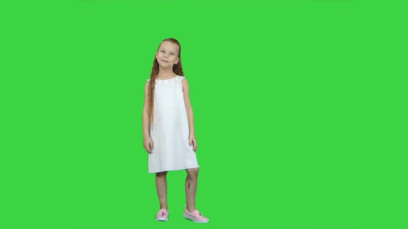 Adorable Little Girl Smiling at Camera and Posing on a Green Screen, Chroma Key