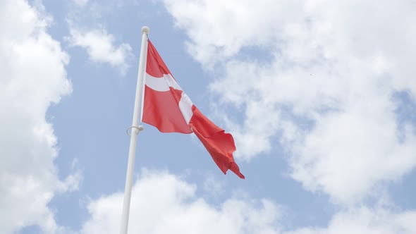 Famous Denmark national flag in front of cloudy sky waving 4K 2160p 30fps UHD footage - Red and whit