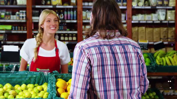 Smiling staff assisting a man with grocery shopping