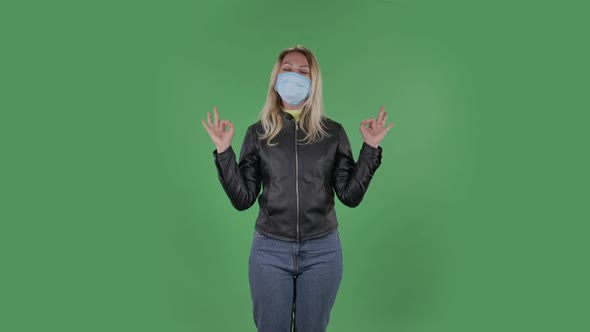 Portrait of Beautiful Young Woman in Medical Protective Face Mask Is Looking at Camera Is Relaxing