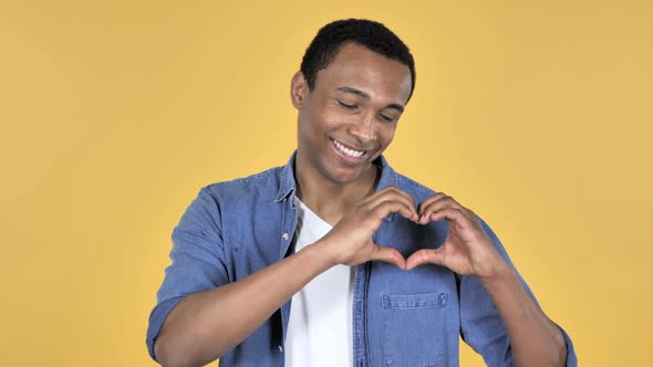 Handmade Heart By Young African Man Yellow Background