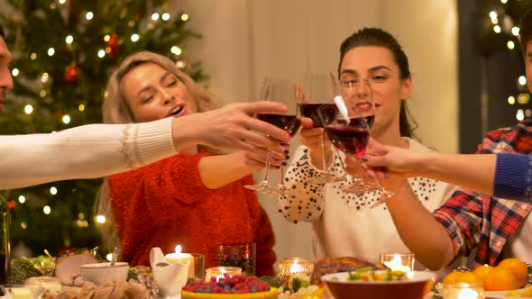 Happy Friends Drinking Red Wine at Christmas