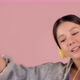 Pretty Asian girl listening music and dancing on pink background. - VideoHive Item for Sale