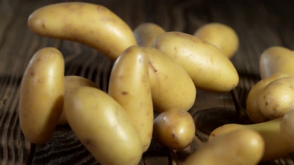 Super Slow Motion Shot of Potatoes Rolling on Old Wooden Table at 1000Fps