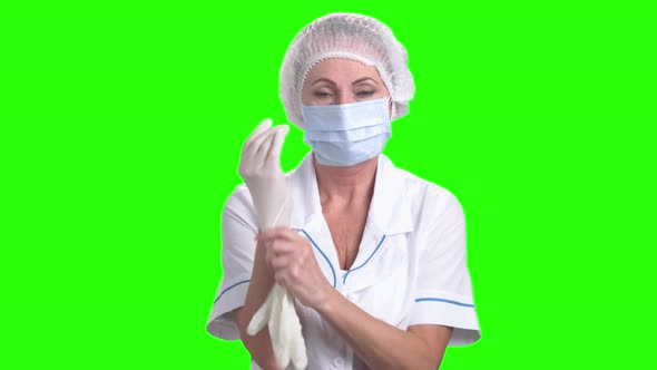 Female Surgeon Putting on Protective Gloves.