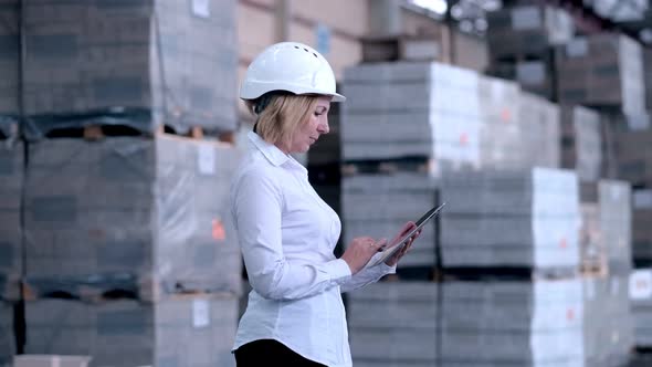 Follow Footage of Employees Famale Warehouse Worker Engineer in Hard Hat Working