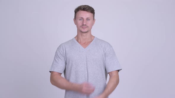 Handsome Bearded Man with Arms Crossed Against White Background