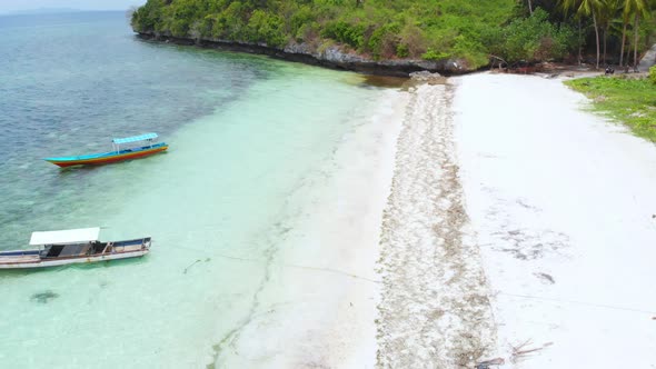 Aerial: Flying over tropical beach turquoise water coral reef, Indonesia 