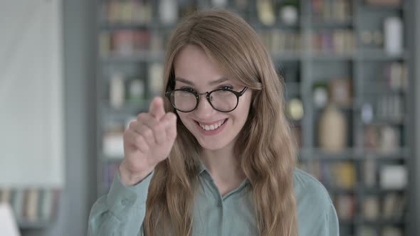 Portrait of Cheerful Young Woman Pointing Finger at Camera
