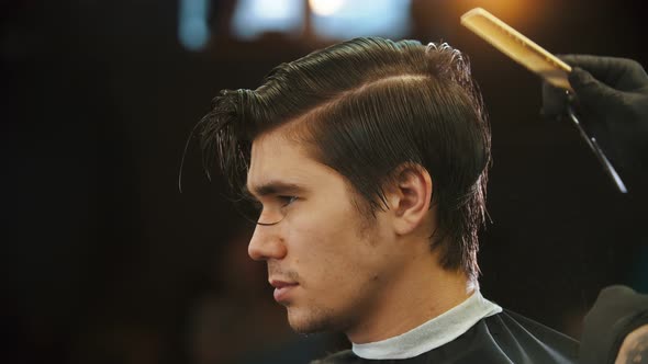 A Young Man Having a Haircut in Barbershop