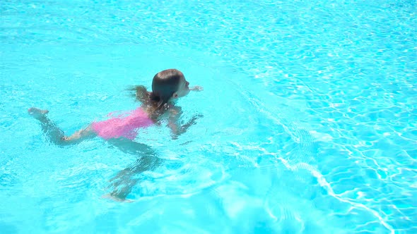 Adorable Little Girl Swimming at Outdoor Swimming Pool