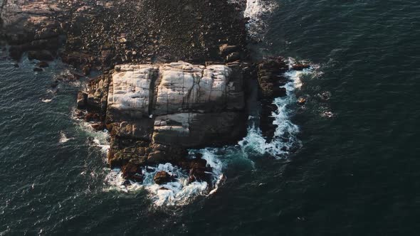 Stunning Shot Of Deep Blue Ocean With Foamy Waves Splashing In Slow Motion On The Rocks In Glouceste