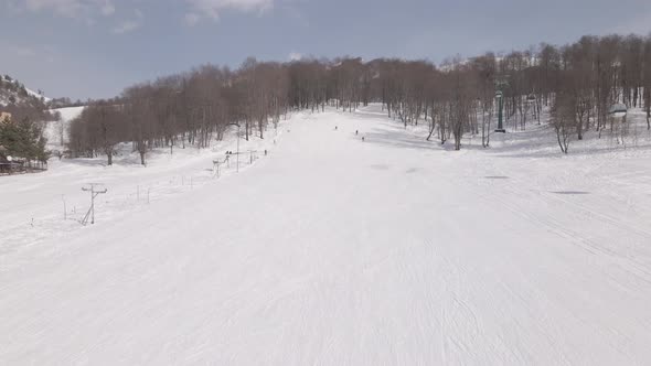 Aerial view of the ski resort with snowy mountain slopes and winter trees. 