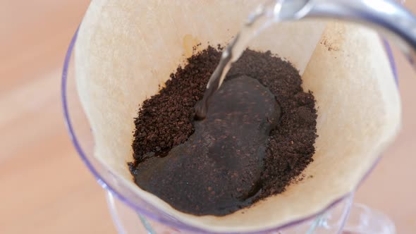 Water pouring to the coffee filter, making of hand drip coffee