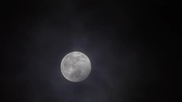 Full Moon Moving Between Clouds