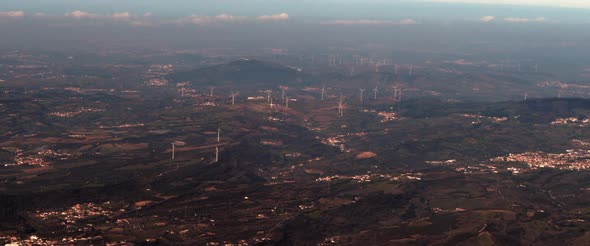 Aerial view of wind turbines and small districts from the window of a plane