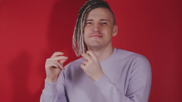 Young handsome cheerful man dancing, snapping fingers, looking at camera.