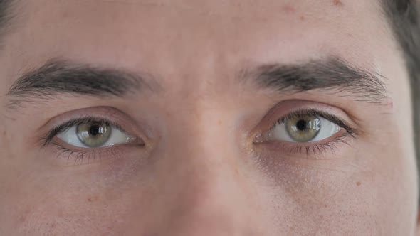 Close Up of Blinking Eyes of Young Man Looking at Camera