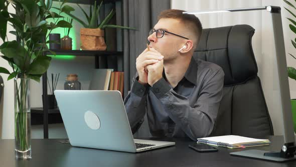 Focused male is looking away, thinking of new project ideas at work in office