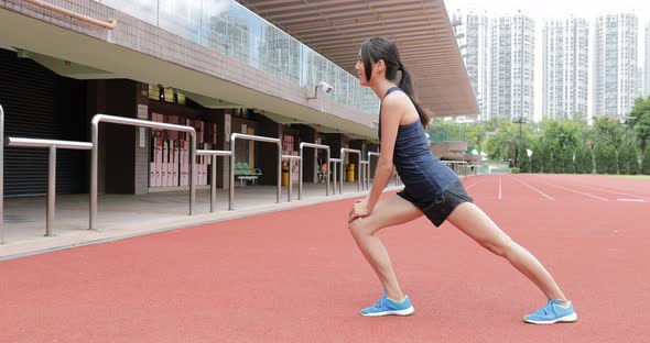 Woman stretching legs in Sport running track