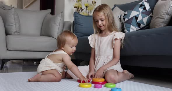 Two Cute Little Caucasian Children Siblings Playing Together with Wooden Toys on Floor at Home