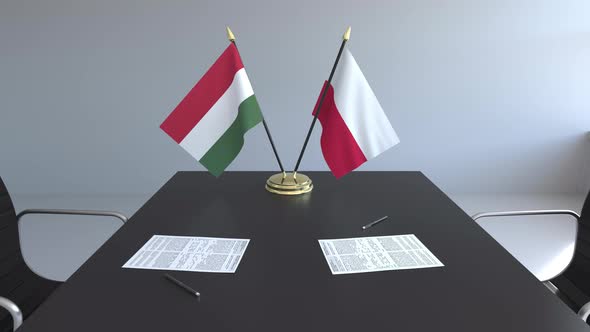 Flags of Hungary and Poland and Papers on the Table