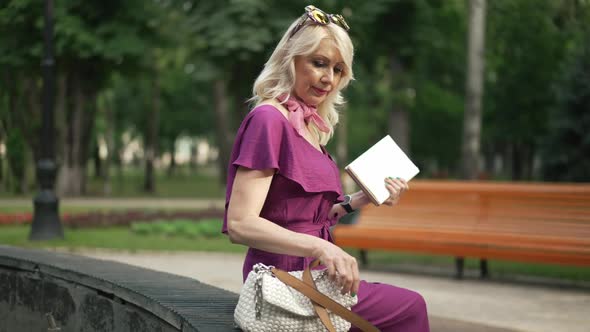 Side View Happy Woman Closing Book Walking Away in Urban City Park on Sunny Day Outdoors