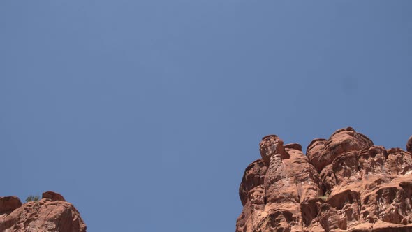 Wide shot of the sky as the camera slowly tilts down to the entrance to the Long Canyon Slot in the