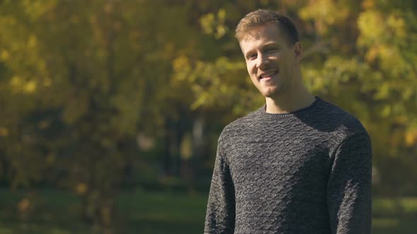 Happy Man Laughing and Showing Thumbs Up Outdoors