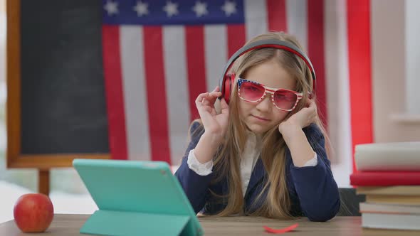 Confident Positive Teenage Schoolgirl in Sunglasses and Headphones Looking at Camera Listening to alt