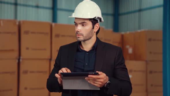 Factory Manager Using Tablet Computer in Warehouse or Factory