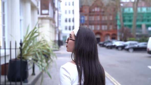 Young woman turns, hair flips, Soho, London, medium shot slow motion