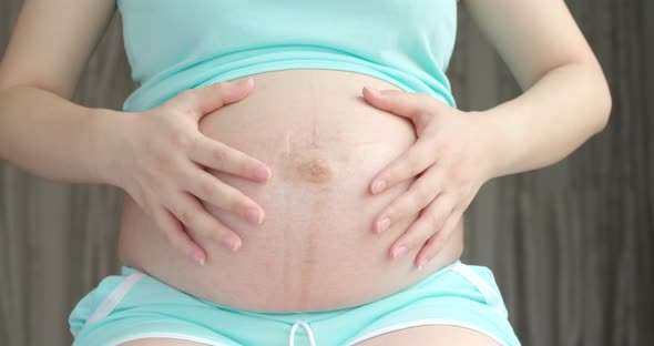 Pregnant woman touching on her belly 