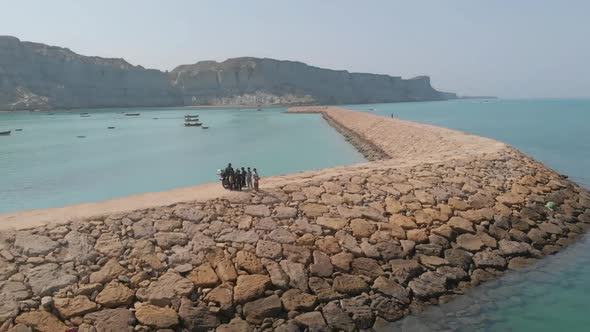 Aerial Backward drone shot of path between water. Aerial shot of Makran Coastal Highway along Pakist