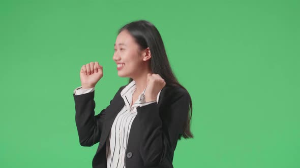 Side View Of Business Woman Dancing While Standing On Green Screen Background In The In The Studio