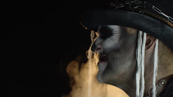 Crazy Man with Horrible Halloween Skeleton Makeup Making Faces, Showing Tongue, Trying To Scare