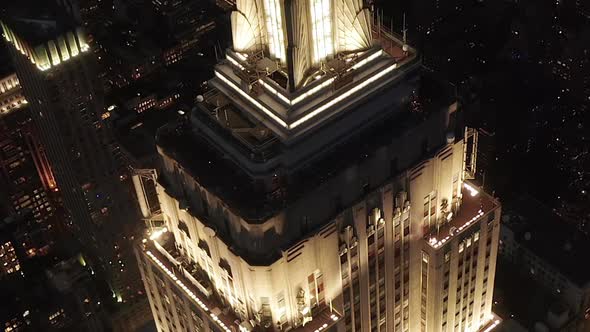 AERIAL: Epic Close Up Heli Shot of Empire State Building Above Lit Up Parallel Avenues and Junctions