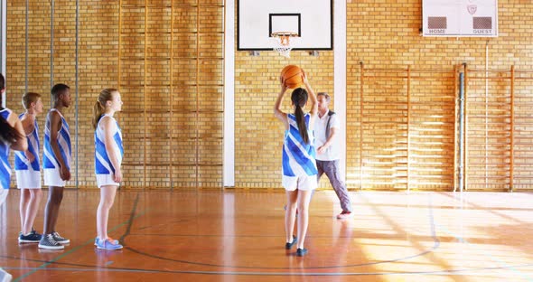 Coach mentoring high school kids In basketball court 4k