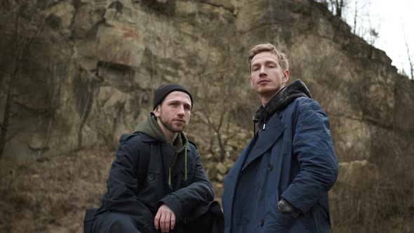 Two Friends In Nature. Stylish Young Guys. Behind Them Is Rock.