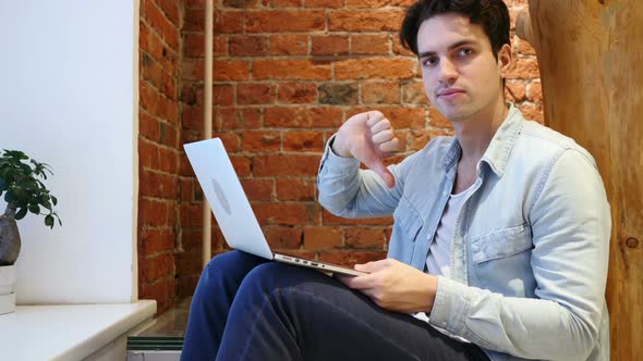 Thumbs Down by Man Working on Laptop, Loft Office