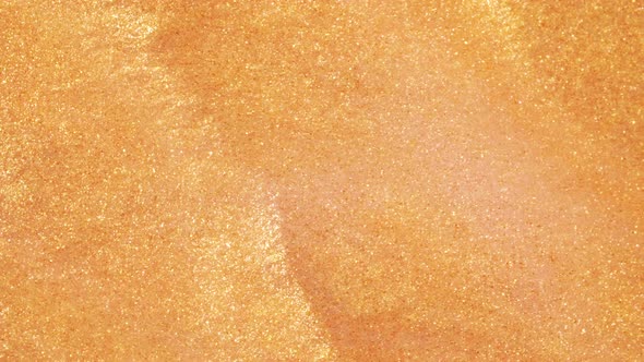 Colorful Golden Sand Organically Moves in Colorful Liquid in Macro