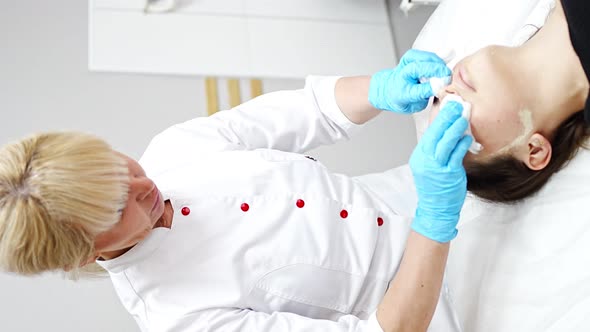 Beutician Doctor Wiping Patient's Face with Cotton Pads