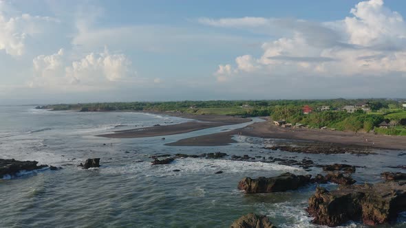 Aerial Footage of Black Volcanic Beach, Green Rice Terraces. Bali, Indonesia